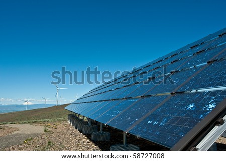 Giant wind turbines and solar panel on a mountain ridge