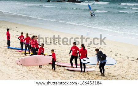 PONTEVEDRA, OCTOBER 27: Youth belonging to a surf school warm-up exercise before surfing the waves on the beach A Lanzada in Galicia (Spain) during the fall, October 27, 2013.