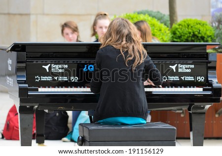 BILBAO, SPAIN - APRIL 4, 2014: A girl plays a grand piano during music initiative 