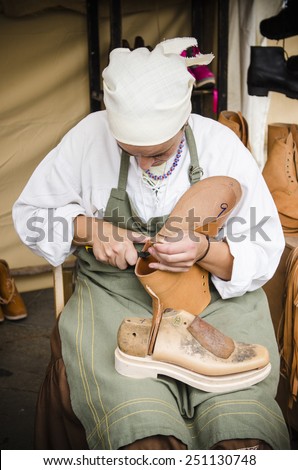 PONTEVEDRA, SPAIN - SEPTEMBER 6, 2014: A shoemaker manufactures boots, in medieval festival held each year in the historical district of the city.