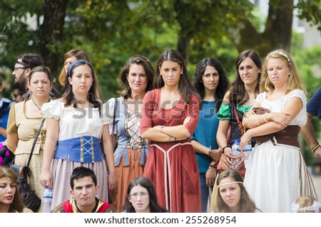 PONTEVEDRA, SPAIN - SEPTEMBER 6, 2014: A group of people in costumes from the Middle Ages enjoy a show in the street, in medieval festival held each year in the historical district of the city.