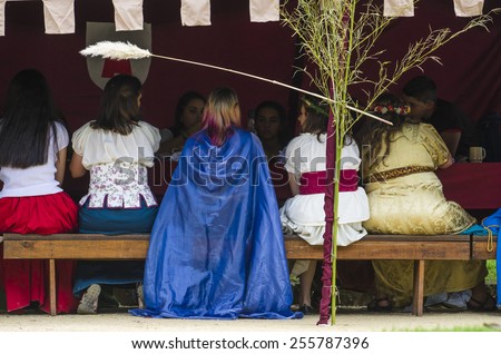 PONTEVEDRA, SPAIN - SEPTEMBER 6, 2014: A group of people in costumes from the Middle Ages snacks under a tent, in medieval festival held each year in the historical district of the city.