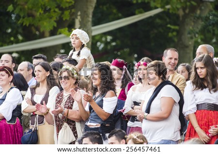 PONTEVEDRA, SPAIN - SEPTEMBER 6, 2014: A group of people dressed in costumes from the Middle Ages, enjoy one of the shows on the street, in medieval festival held each year in the city.