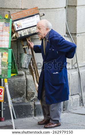 SEGOVIA, SPAIN - SEPTEMBER 20, 2014: An old man with a huge old camera, rest after a day of work in the city.