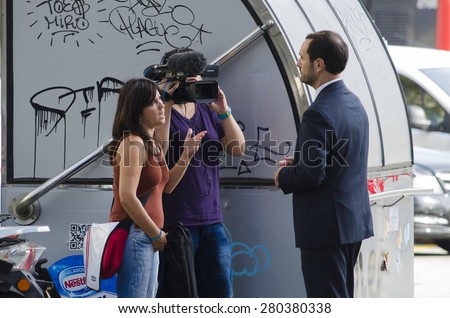 BARCELONA, SPAIN - OCTOBER 7, 2014: Some journalists conducted an interview with a video camera, a man in one of the streets of their city.