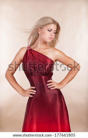 Portrait of beautiful blonde woman in red dress fashion studio, sexy young girl in red dress. Elegant romantic woman in long red dress. Summer fashion.