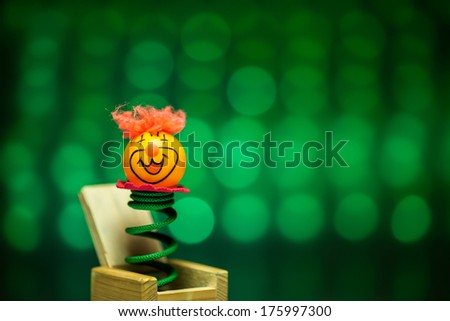 Little clown ping pong welcome surprise from wood box with blue blurry circle background