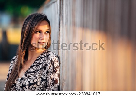 Portrait of Attractive Young Woman Looking at sun between railing gaps