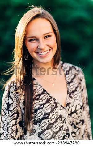 Portrait of an Attractive Young Woman Looking right at camera smiling and laughing close up