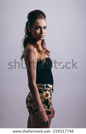Studio Portrait of Young Attractive Woman body facing away from camera face looking at camera