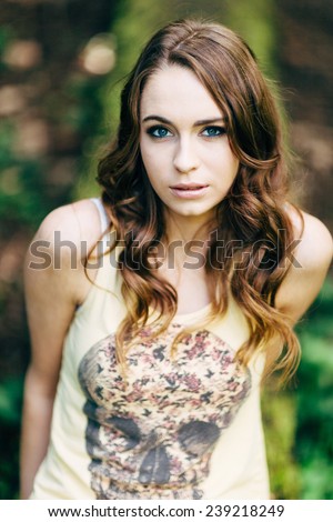 Portrait of Young Attractive Woman with beautiful blue eyes looking up at camera with skull t-shirt