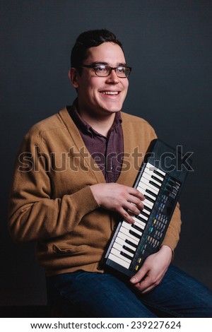 cheesy portrait of a man smiling silly playing piano