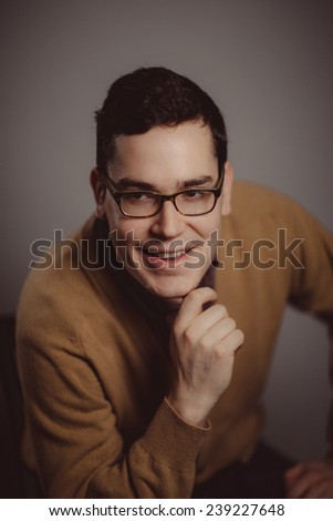 cheesy and silly 1950-1970 portrait of young adult man with hand on chin smiling