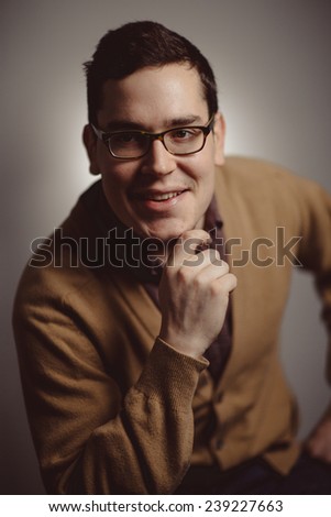 cheesy and silly 1950-1970 portrait of young adult man with hand on chin smiling  chin smiling  wide
