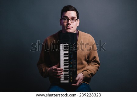serious musician chin on small keyboard eyebrows raised