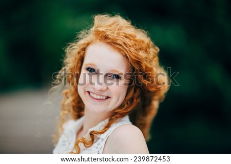 Attractive Young Female Redhead, smiling with hair blowing