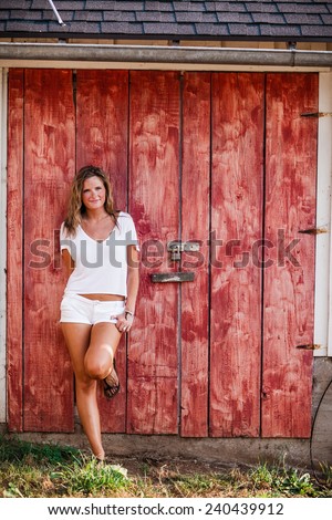 Beautiful Blonde Young Woman standing against red barn door leg up smile variation hand on pocket
