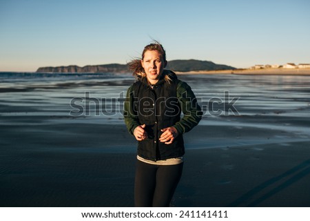 Female Runner on the Beach at Sunset serious run