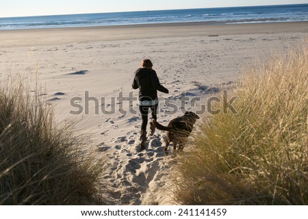 Chocolate Lab Running on Beach with owner