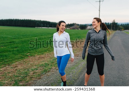 Young Adult Females laughing with each other during a run