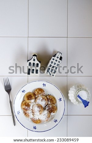 Typical Dutch food called poffertjes  with delfs bleu houses and a sugar pot ,on a white background