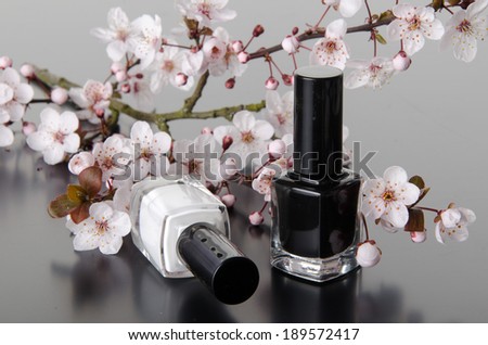 Nail polish with flowers, on grey background