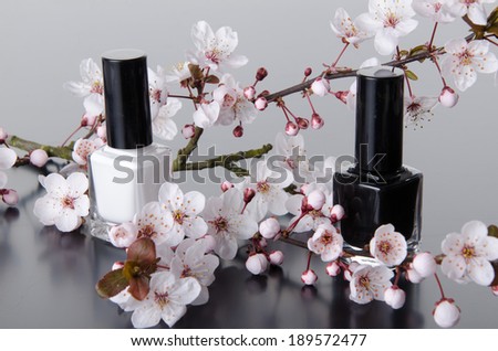 Nail polish with flowers, on grey background