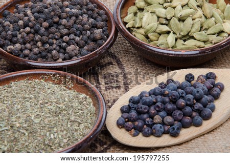 Composition with pepper, cardamom, juniper berries and provencal herbs on a burlap bag