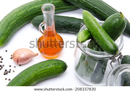 Composition with cucumbers, a glass jar and vinegar, isolated on white