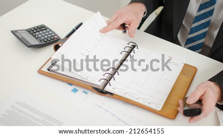Businessman looking at his diary for take an appointment