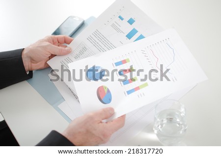 Businessman analyzing economic documents at the office