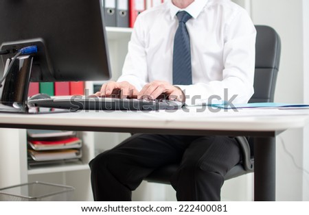 Businessman in office working on desktop computer