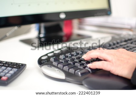 Woman\'s hand typing on a keyboard