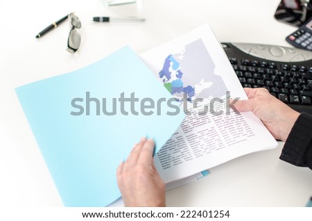 Woman\'s hand removing an economic document from a file folder