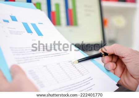 Hand of businessman holding an economic document at the office