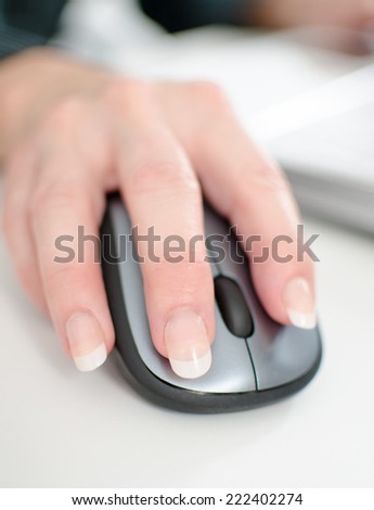 Businesswoman\'s hand holding a computer mouse, closeup