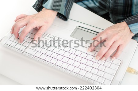 Female hands typing on a white laptop computer keyboard