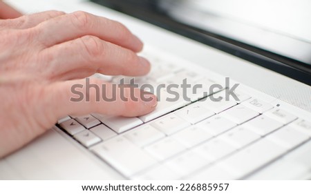 Hand typing on a keyboard, closeup