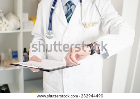 Doctor looking at his watch at office
