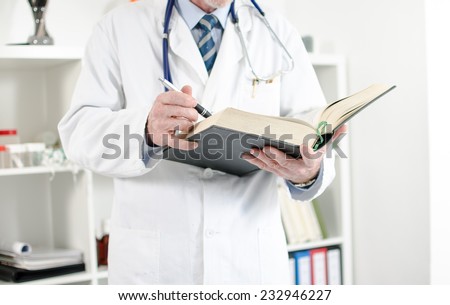 Doctor reading a medical book in his office