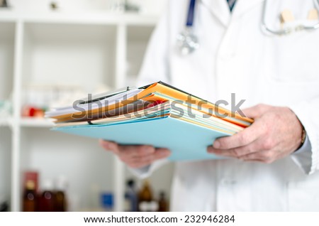 Doctor holding files in his office