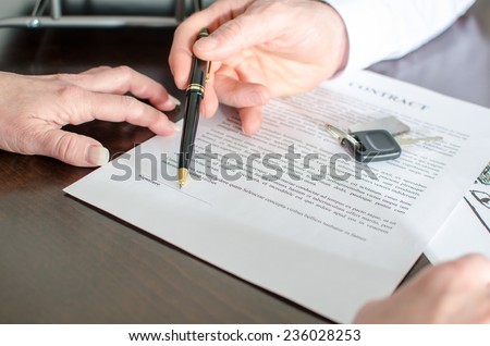 Dealer showing the signature place of a contract with his pen