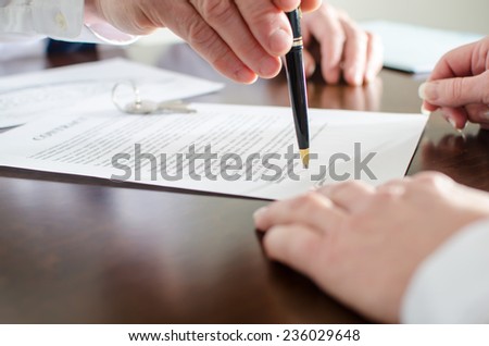Realtor showing the signature place of a contract with his pen