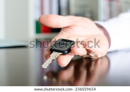 Salesman holding car key in his hand