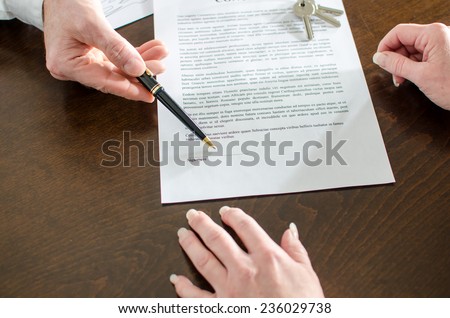 Realtor showing the signature place of a contract with his pen