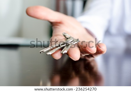 Estate agent showing house keys on a wooden table