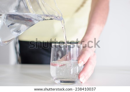 Woman pouring water from a jug into a glass