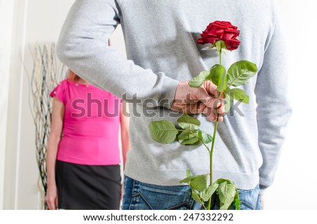 Man holding a rose behind his back for Valentine\'s day
