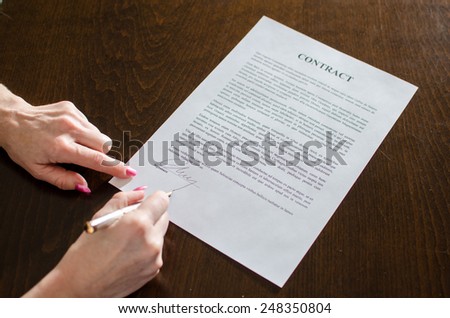 Hand of a woman signing a contract
