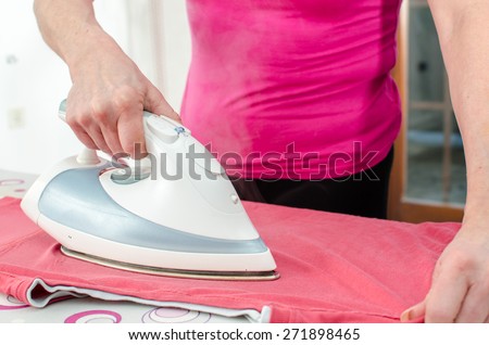 Woman ironing a red tee shirt